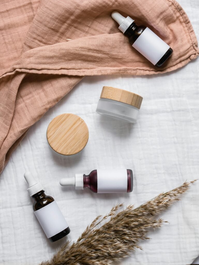 oil-1 Stylish flat lay of serum bottles and jars on soft fabric with a natural, earthy aesthetic.