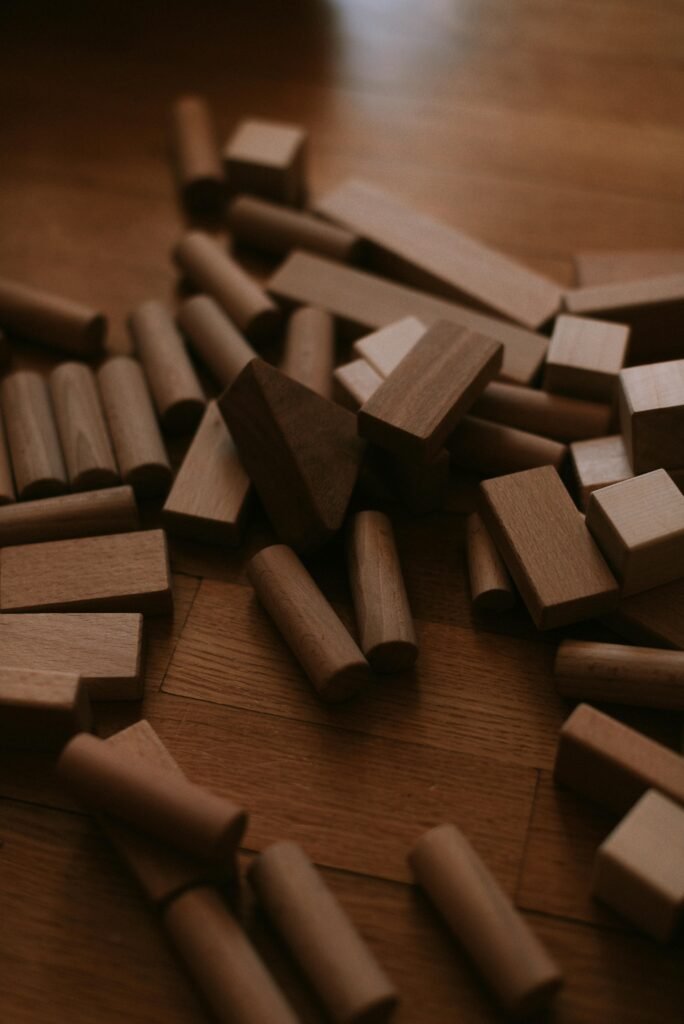 automotive A pile of natural wooden building blocks scattered on a wooden floor.